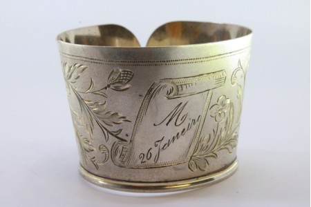 Argola de guardanapo em prata em forma de punho e  motivos florais gravados envolvendo cartela para monograma.